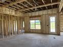 Unfinished new construction interior with framing, insulation, concrete floor, and view to the outside at 4971 Dupont Rd., Aynor, SC 29511