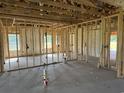 Unfinished new construction interior with framing, insulation, concrete floor, and view to the outside at 4971 Dupont Rd., Aynor, SC 29511