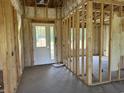 Unfinished new construction showing the framing, insulation, door to the outside and concrete floor at 4971 Dupont Rd., Aynor, SC 29511