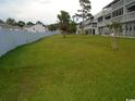 Community backyard with ample green space and fence at 500 Fairway Village Dr. # 7-C, Myrtle Beach, SC 29588