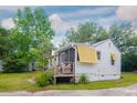 This image features the back of the home with a screened porch and lush green foliage at 640 Willowbank Rd., Georgetown, SC 29440