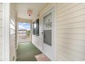 Cozy screened-in porch featuring a storm door with “Welcome to the Beach” decor at 673 Tupelo Ln. # G, Longs, SC 29568