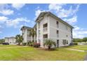 Exterior view of a three story condo complex with tropical landscaping and parking at 673 Tupelo Ln. # G, Longs, SC 29568