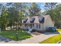 Landscaped exterior with a quaint covered porch, inviting entryway, and spacious driveway, complete with parking at 6864 Woodhaven Dr., Myrtle Beach, SC 29588