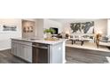 Open-concept kitchen with granite countertops, stainless steel appliances, and seamless flow into the living room at 7399 Meadow Walk Loop, Loris, SC 29569