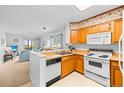 Bright kitchen open to the living area, featuring white appliances and wooden cabinets at 9501 Shore Dr. # C-328, Myrtle Beach, SC 29572