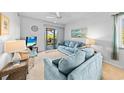 Cozy living room with a plush blue sofa, wicker accents, and access to the balcony at 9501 Shore Dr. # C-328, Myrtle Beach, SC 29572