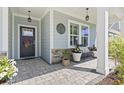 Inviting front porch featuring stone accents, decorative plants, and a cozy bench for relaxing at 1010 Graybill Lane, North Myrtle Beach, SC 29582