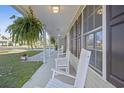 Long, covered front porch featuring white columns and rocking chairs, great for enjoying the outdoors at 113 Edwards Ln., Longs, SC 29568