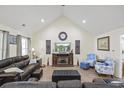 Spacious living room with vaulted ceilings, hardwood floors, a fireplace, comfortable furniture and bright natural lighting at 113 Edwards Ln., Longs, SC 29568