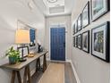 Inviting entryway with wood floors, console table, mirror, and artwork leading to the front door at 127 Emerald Rush Ct., Longs, SC 29568
