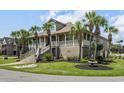 Charming home featuring a spacious wrap-around porch, manicured lawn, and a decorative water fountain at 130 Pier Pointe Dr., Little River, SC 29566