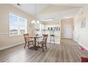 Cozy dining area with natural light adjacent to the kitchen featuring barstool seating and wood flooring at 200 Castle Dr. # 1369, Myrtle Beach, SC 29579