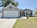 Inviting single-story home with tidy landscaping and a white two car garage door at 2217 Belladora Rd., Conway, SC 29527