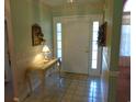 Entryway boasting tile floors, elegant table with lamp, and a welcoming front door with sidelights at 2333 Brick Dr., Longs, SC 29568