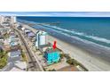 Aerial view of a teal beach house near the ocean with a pier in the background at 2808 N Ocean Blvd., North Myrtle Beach, SC 29582