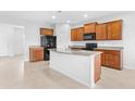 Open kitchen boasts granite countertops, dark wood cabinetry, stainless steel appliances, and a large island at 4009 Alvina Way, Myrtle Beach, SC 29579