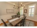Elegant dining room featuring wood floors, a classic chandelier, and bright windows at 4535 Carriage Run Circle, Murrells Inlet, SC 29576