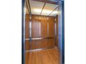 Modern elevator with wood paneling, brushed silver trim, and hardwood floor at 4741 Wild Iris Dr. # 303, Myrtle Beach, SC 29577