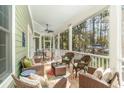 Relaxing screened porch with wicker furniture, ceiling fan, and wooded views at 487 Lantana Circle, Georgetown, SC 29440