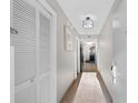 Long hallway featuring neutral tile floors, white walls, storage and an ornate light fixture at 5200 N Ocean Blvd. # 833, Myrtle Beach, SC 29577