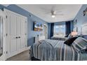 Charming blue bedroom with two beds, a ceiling fan, a TV, and natural light from the large window at 603 S Ocean Blvd. # 1101, North Myrtle Beach, SC 29582