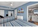 Well-decorated bedroom with blue walls, two beds, a TV, and an attached bathroom with a vanity at 603 S Ocean Blvd. # 1101, North Myrtle Beach, SC 29582