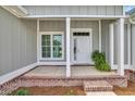 Inviting front porch with brick accents, white columns, and a well-lit entrance at 604 Highway 747, Loris, SC 29569