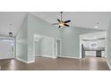 Open-concept living room with high ceilings, ceiling fan, and wood-look floors at 604 Highway 747, Loris, SC 29569