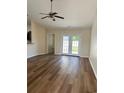 Bright living room featuring wood floors, ceiling fan, and glass doors leading to the outside at 753 Bucklin Loop, Myrtle Beach, SC 29579