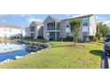 Beautiful condominium exterior featuring a serene pond and well-maintained landscaping at 8796 Cloister Dr. # B, Surfside Beach, SC 29575