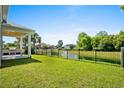 Fenced backyard overlooking a pond with mature trees and outdoor kitchen at 985 Shipmaster Ave., Myrtle Beach, SC 29579