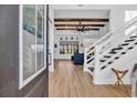 Inviting foyer with wood floors, white staircase, and an open view into the living room with wood beam ceiling at 1004 Whooping Crane Dr., Conway, SC 29526