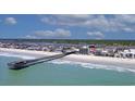 Coastal aerial view featuring a long wooden pier, beach and residential community at 126 N Waccamaw Dr. # 101, Garden City Beach, SC 29576