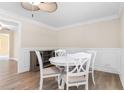 Cozy dining room with elegant wainscoting, modern ceiling fan, and stylish white table set at 131 Oak Log Lake Rd., Conway, SC 29526