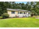 Cozy single-story home featuring a well-manicured lawn, a quaint porch and a welcoming entrance at 131 Oak Log Lake Rd., Conway, SC 29526