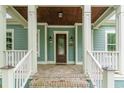 Inviting front porch with detailed columns, warm wood ceiling, and stylish front door at 1400 James Island Ave., North Myrtle Beach, SC 29582