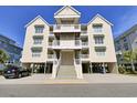 Lovely condo showcasing three stories, covered parking, and multiple balconies on a sunny, clear day at 156 Via Old Sound Blvd. # C, Ocean Isle Beach, NC 28469