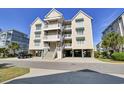 Charming three-story condo with multiple balconies and convenient covered parking, set against a bright blue sky at 156 Via Old Sound Blvd. # C, Ocean Isle Beach, NC 28469