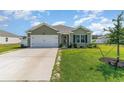 Charming single-story home featuring a well-manicured lawn, attached garage, and welcoming front entrance at 211 Seasons Trace Loop, Longs, SC 29568