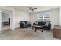 Comfortable living room with large window, ceiling fan, wood-look flooring and two comfortable sofas at 211 Seasons Trace Loop, Longs, SC 29568