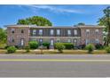 A row of brick townhomes features well-kept lawns and inviting front entrances at 2701 Hillside Dr. S # 1, North Myrtle Beach, SC 29582
