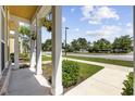 Covered porch with hanging plants and decorative columns overlooking the manicured lawn at 3550 Pampas Dr. # 2, Myrtle Beach, SC 29577