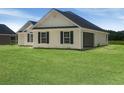 View of the rear of a new home with an attached garage featuring dark shutters and an immaculate lawn at 3601 Valley Forge Rd., Aynor, SC 29511