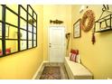 Welcoming entryway with yellow walls, decor, a wooden bench, and an ornate mirror, creating a warm first impression at 512 Chanted Dr., Murrells Inlet, SC 29576
