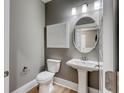 Stylish powder room featuring elegant pedestal sink, oval mirror, and modern lighting at 543 Oak Landing Dr., Myrtle Beach, SC 29588
