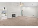 Spacious living room featuring a fireplace, ceiling fan, and neutral carpeting at 68 Voyagers Dr., Pawleys Island, SC 29585