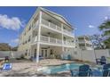 Beautiful three-story home with a pool, outdoor seating, and multiple balconies, ideal for entertaining and enjoying coastal living at 703 37Th Ave. S, North Myrtle Beach, SC 29582