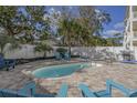 Relaxing backyard pool area with brick pavers, Adirondack chairs, and lush landscaping for ultimate outdoor enjoyment at 703 37Th Ave. S, North Myrtle Beach, SC 29582