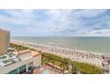 Aerial view of the beach, pool, and ocean with plenty of beachgoers enjoying the sun at 7200 N Ocean Blvd. # 1058, Myrtle Beach, SC 29572